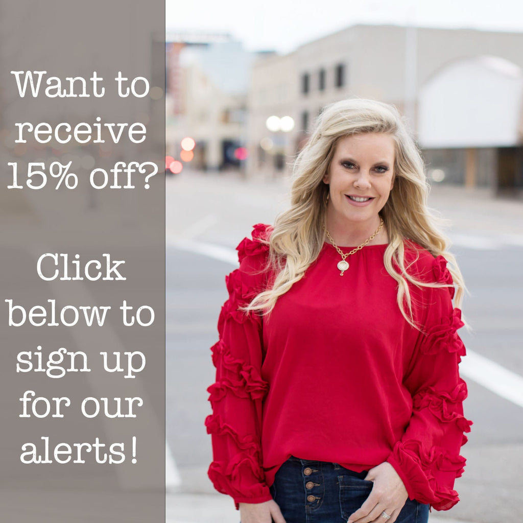 Want to receive 15% off? Click to sign up for our alerts! | Woman standing in the street wearing a red balloon and ruffle sleeve top with an offer to receive 15% off your next purchase for signing up for text alerts - click the link below - Shop Timber Brooke Boutique, a women's online boutique, Amarillo Texas